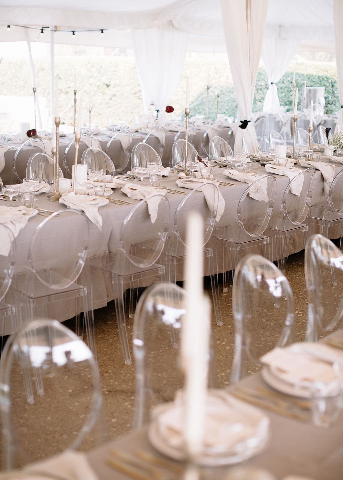 Ghost chairs along a styled reception table