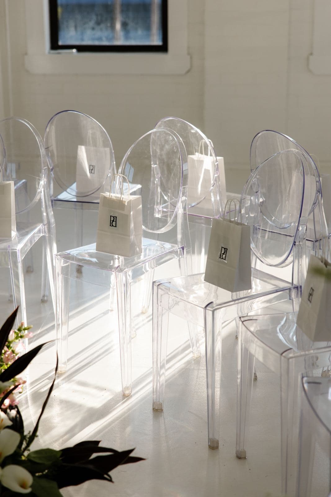 Rows of ghost chairs in a sunlit white studio